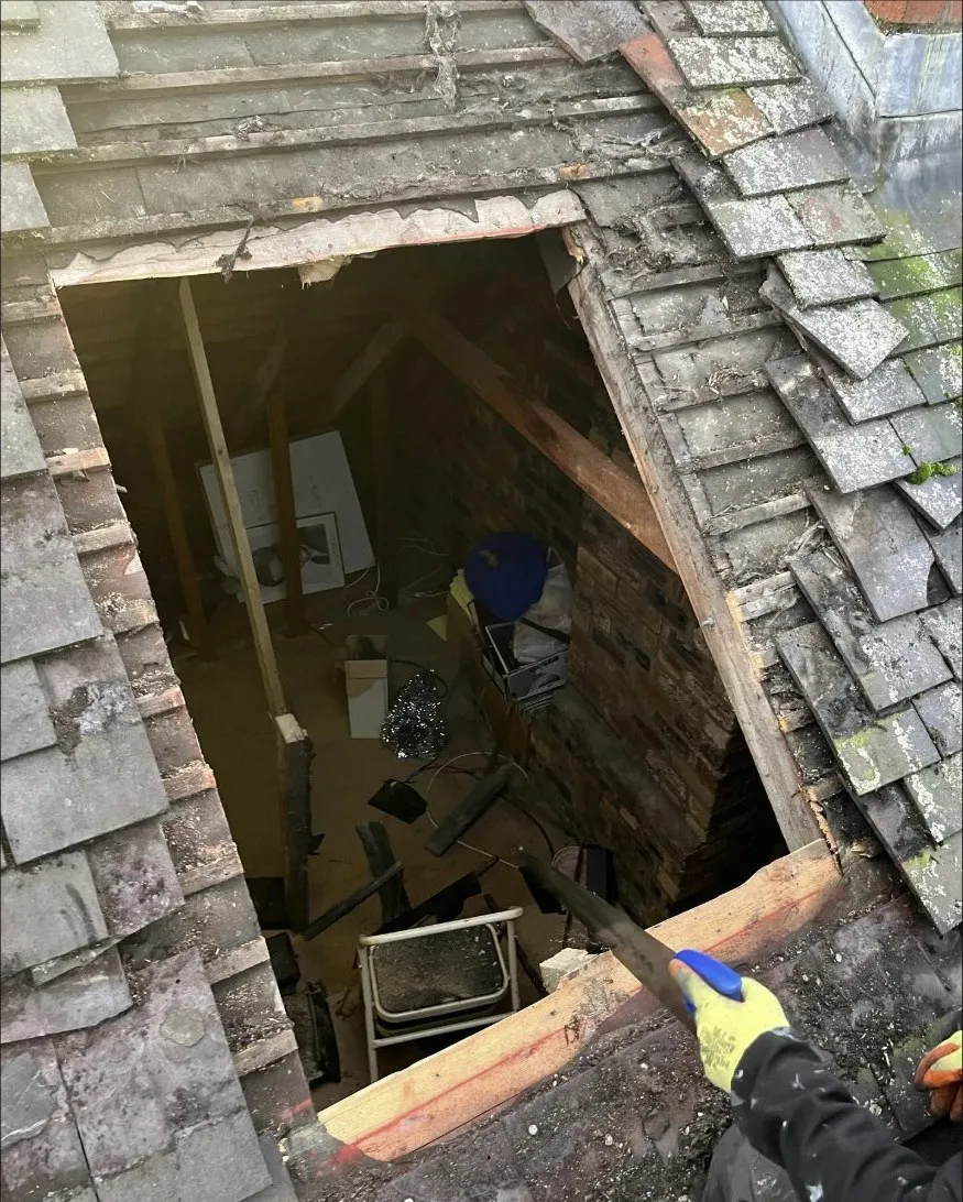 A roof opened right up with the slates off, the timbers and the loft below visible