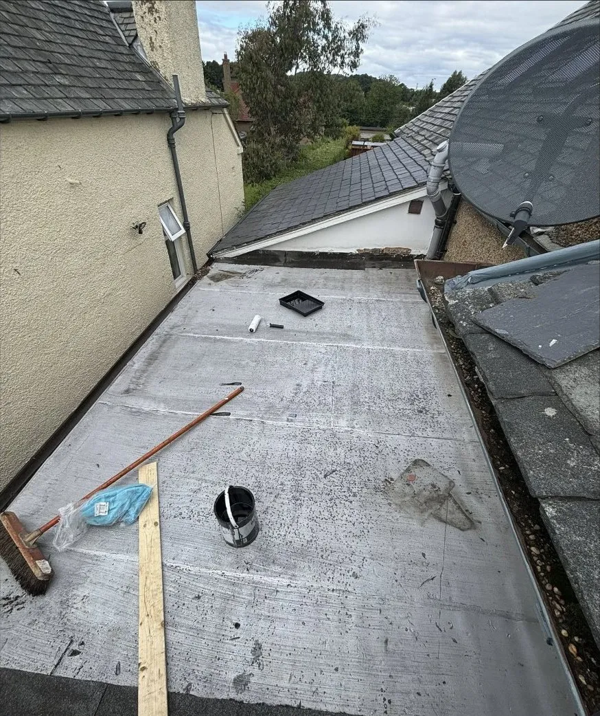 A flat roof mid job, tools and materials out across it